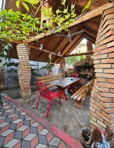 a patio with a table and a red chair at Apartman Centar in Srbobran