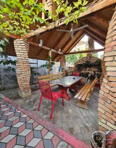a patio with a table and a bench under a roof at Apartman Centar in Srbobran