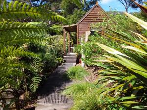 a garden path leading to a small building at The Bali Room in Coromandel Town