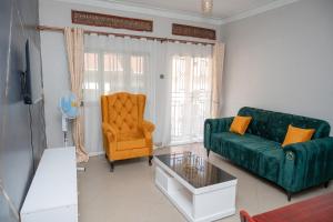 uma sala de estar com um sofá verde e uma cadeira em Macky cottages em Kampala