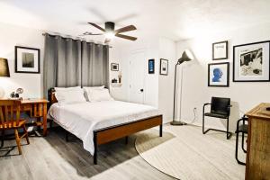 a bedroom with a bed and a desk and a ceiling fan at Chic & Cozy Retreat For Romantic Spring Getaways in Oklahoma City