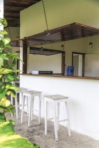 a white counter with two stools and a mirror at Casas Oceanicas in Icaraí