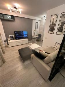 a living room with a couch and a flat screen tv at Boutique Apartment in Bucharest