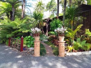 a garden with two vases with flowers in it at The Bali Room in Coromandel Town