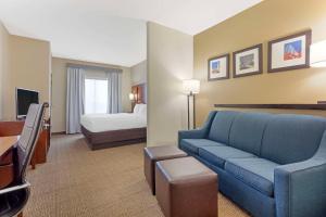 a hotel room with a couch and a bed at Comfort Suites West Dallas - Cockrell Hill in Dallas