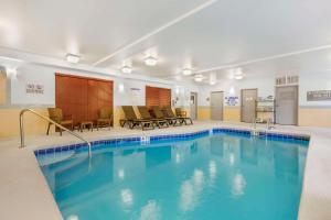 a pool in a hotel room with chairs and tables at Comfort Suites Columbia Northeast - Fort Jackson in Columbia