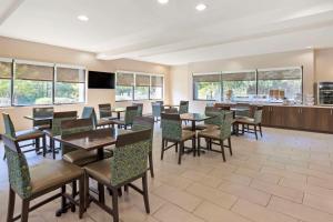 a dining room with tables and chairs and windows at Comfort Suites Columbia Northeast - Fort Jackson in Columbia