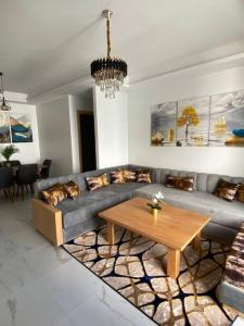 uma sala de estar com um sofá e uma mesa em Belle appartement à découvrir em El Harhoura