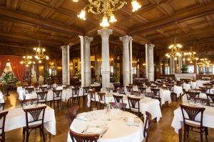 a banquet hall with white tables and chairs at Grand Hôtel Moderne in Lourdes