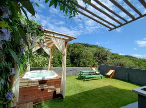 um quintal com uma banheira de hidromassagem e uma pérgola em Morro Apartment Vista Mar em Morro de São Paulo