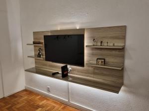 a flat screen tv on a wall with shelves at Apartamento quarto e sala in Rio de Janeiro