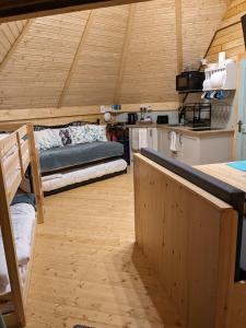 a large room with a bed and a kitchen at Woods Meadow Glamping in West Malling