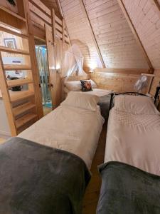 una camera con tre letti in una piccola stanza di Woods Meadow Glamping a West Malling