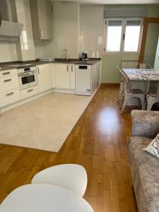 een keuken en een woonkamer met een tafel en een bank bij Apartamento Rural El Estrecho de Arguedas in Arguedas