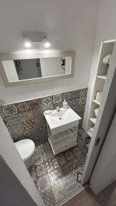 y baño con lavabo, aseo y espejo. en Apartamento Alberdi 1634 en Buenos Aires