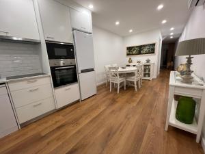 a kitchen and dining room with white cabinets and a table at Urban 41 Guest House in Ponta Delgada