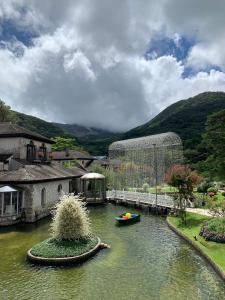 a small boat in a body of water next to a building at HAKONE DOMA in Hakone