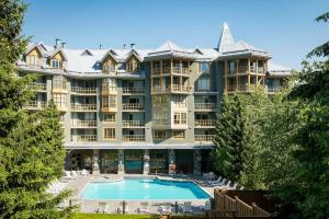 um grande edifício de apartamentos com uma grande piscina em 600 SQFT 1 Bed 1 Bath Mountain View Suite at Cascade Lodge in Whistler Village Sleeps 4 em Whistler