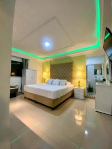 a bedroom with a large bed with green lights at Hotel West California in Armenia