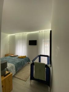 a bedroom with a bed and a chair at Urban 44 Guest House in Ponta Delgada