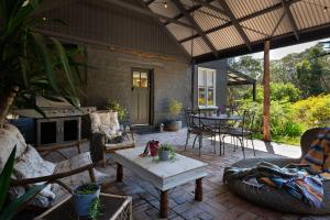 a patio with a table and chairs and a fireplace at Edessa Lodge in Glenlyon