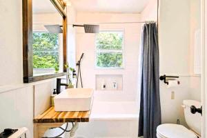 a bathroom with a sink and a toilet and a window at Stylish Farmhouse Retreat I 6 Min To Plaza Dist in Oklahoma City