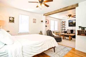 a bedroom with a white bed and a living room at Stylish Farmhouse Retreat I 6 Min To Plaza Dist in Oklahoma City