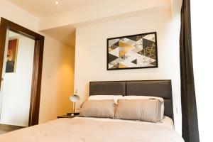 ein Schlafzimmer mit einem Bett und einem Bild an der Wand in der Unterkunft Chic Retreat - 1-Bedroom Haven in Accra
