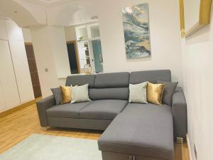 una sala de estar con un sofá gris en una habitación en Bright 2 Bedroom *2 Bathroom* 10 mins to East Croydon, en Croydon