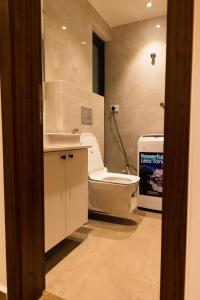 a bathroom with a white toilet and a sink at Chic Retreat - 1-Bedroom Haven in Accra