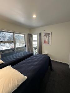 a bedroom with a large bed and a window at Foreshore Mukies 2,0 in Ahipara