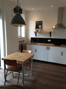 a kitchen with a table and chairs in a kitchen at De Weegbrug in IJzendijke