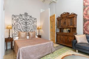 1 dormitorio con cama, silla y vestidor en El Petit Palauet, en Canet de Mar