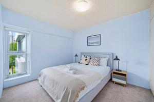 a white bedroom with a bed and a window at Bridge View 2 Bed Apartment at Kirribilli in Sydney