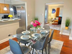 a dining room table with chairs and a vase of flowers at Towson Center BNB in Towson