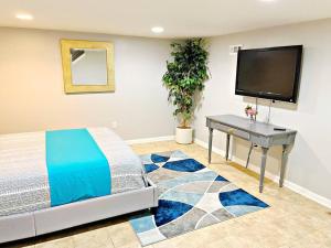 a bedroom with a bed and a desk and a flat screen tv at Towson Center BNB in Towson
