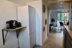 a kitchen with a white refrigerator and a table at Appartement cosy à Perpignan ! in Perpignan