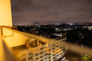 a view of a city at night from a building at Chic Retreat - 1-Bedroom Haven in Accra