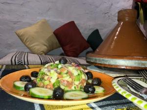 een bord voedsel met komkommers en olijven op een tafel bij Paradise Guest House in Agadir