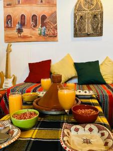 een tafel met borden met voedsel en sinaasappelsap bij Paradise Guest House in Agadir
