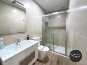 a bathroom with a shower and a toilet and a sink at Apartamentos Blanco & Negro in Tarifa