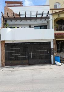 a building with a garage door with a fence at Bonito Departamento Confortable in Tijuana