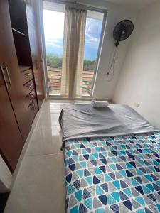 a small bedroom with a bed with a window at APARTAMENTO AMOBLADO EN CONJUNTO CERRADO in Neiva