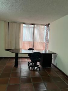 ein leeres Büro mit einem Schreibtisch und einem Stuhl in der Unterkunft Cómoda Habitación Privada - Ciudad Jardín in Cali