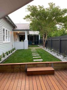 une arrière-cour avec un banc sur une terrasse en bois dans l'établissement House on Drummond, à Ballarat