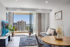 a living room with a table and a large window at Luxury La Isla in Gold Coast