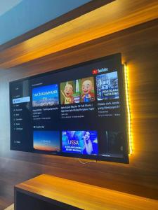 una TV a schermo piatto seduta su una parete di legno di Keypayroom a Kemirimuka Dua