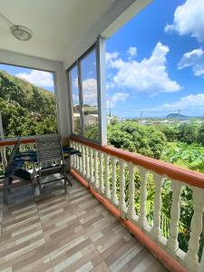 een balkon met uitzicht op de bergen bij Auberge K-WAN Hostel in Deshaies