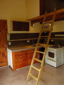 Una escalera en una cocina junto a una estufa en Hermosa casa rodeada de bosque en Los Repollos