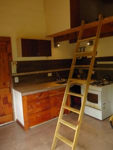 una cocina con una escalera junto a una estufa en Hermosa casa rodeada de bosque en Los Repollos